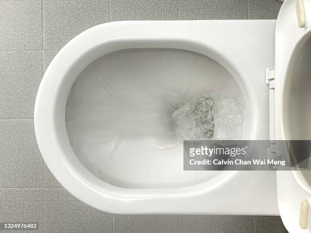 water flushes down toilet bowl - baño fotografías e imágenes de stock