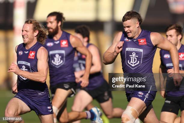 David Mundy and Sean Darcy run during a Fremantle Dockers AFL training session at Victor George Kailis Oval on June 23, 2021 in Perth, Australia.
