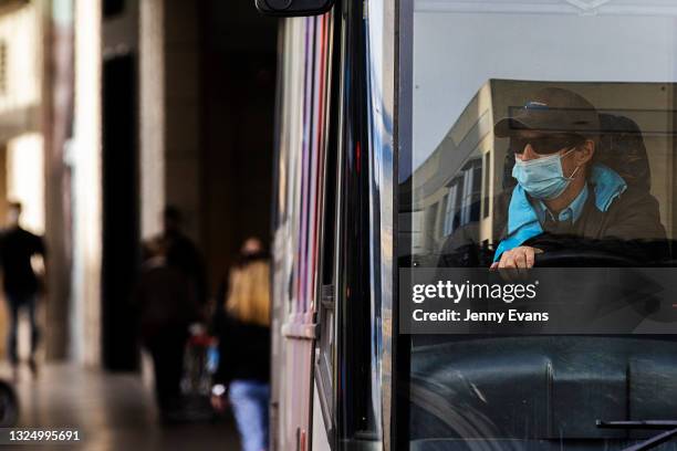 Bus driver wearing a mask drives past Westfield Bondi Junction on June 23, 2021 in Sydney, Australia. Sydney records 16 new locally acquired COVID-19...