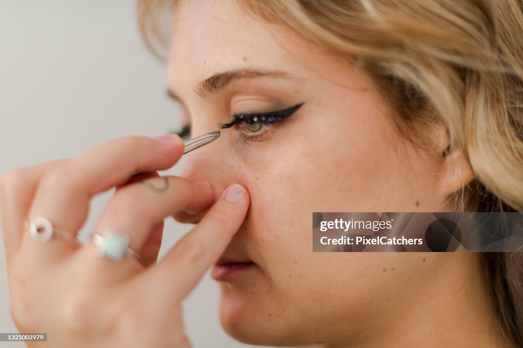 Close up applying false eyelashes with sparkling detail on model