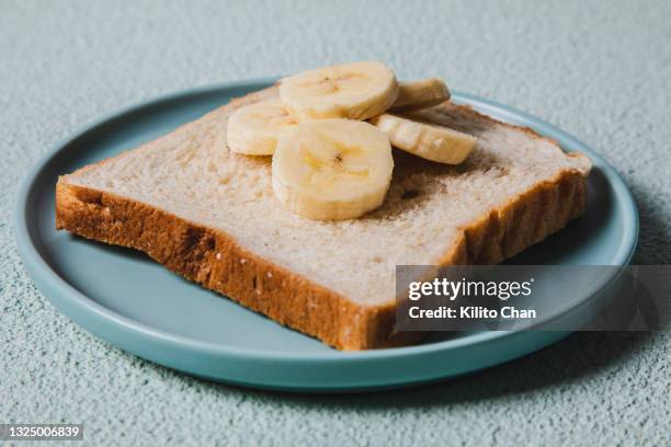 a plate of whole wheat bread with banana slices - bread texture stockfoto's en -beelden