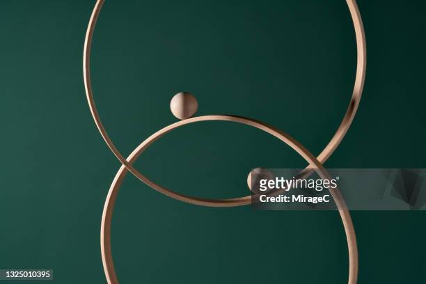 two wooden spheres moves on intersected rings - achteruitrijden stockfoto's en -beelden