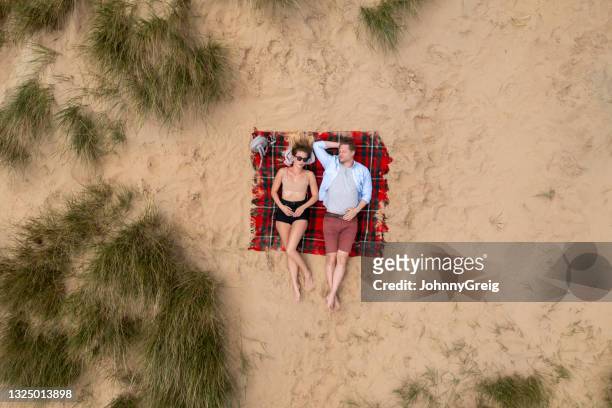kaukasisches paar in den 20er und 30er jahren genießen strandurlaub - couple dunes stock-fotos und bilder
