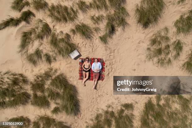 paar in 20er und 30er jahren liegen zusammen auf stranddecke - couple dunes stock-fotos und bilder