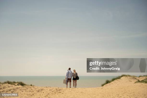 mann und frau im strandurlaub genießen meerblick - couple dunes stock-fotos und bilder