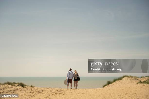 uomo e donna in vacanza al mare godendo della vista sull'oceano - beach dunes foto e immagini stock
