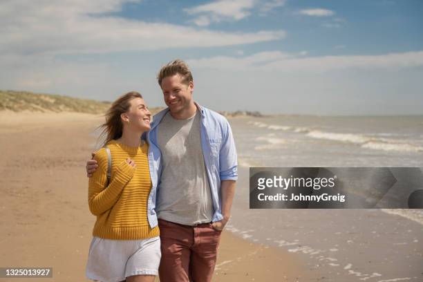 cheerful couple enjoying vacation freedom at the beach - east sussex imagens e fotografias de stock