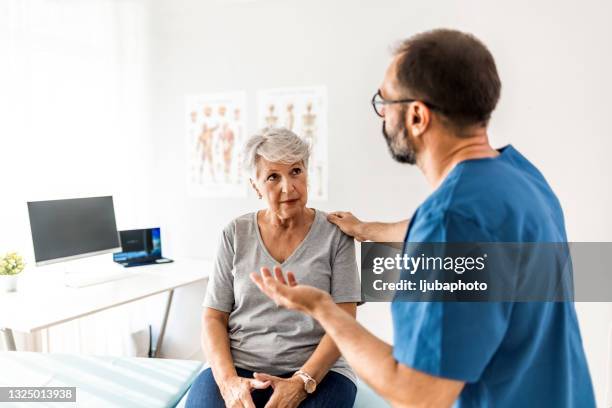 giving careful instructions to his patient - orthopedic surgeon stock pictures, royalty-free photos & images