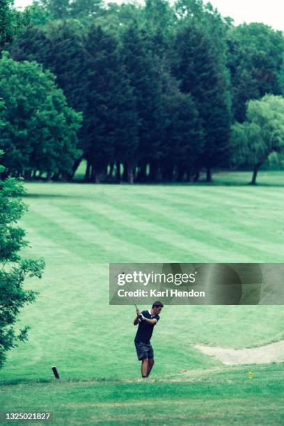 a sunset view of a golfer playing a shot - stock photo - golf swing sunset stock pictures, royalty-free photos & images