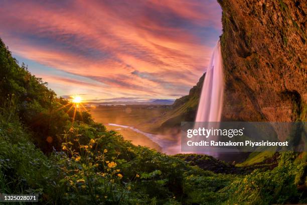 sunset scene of seljalandsfoss is one of the most beautiful waterfalls on the iceland. it is located on the south of the island. with a rainbow. - セリャランスフォス ストックフォトと画像