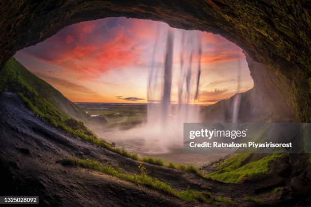 sunset scene of seljalandsfoss is one of the most beautiful waterfalls on the iceland. it is located on the south of the island. with a rainbow. - iceland waterfall stock-fotos und bilder