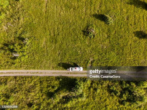 directement au-dessus d’une voiture garée par un chemin de terre dans la scène rurale - rural scene photos et images de collection