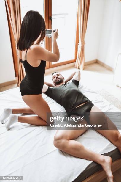 male in underwear getting photo session by girlfriend in bed - photo shoot at home stock pictures, royalty-free photos & images