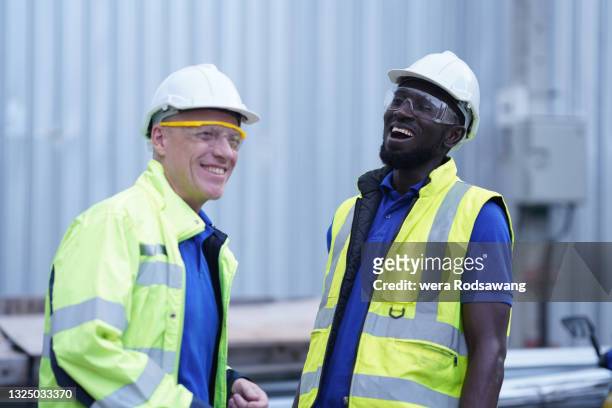 construction engineers laughing together while working at site work - architect object stock pictures, royalty-free photos & images