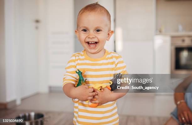 netter kleiner junge hält spielzeug - toy animal stock-fotos und bilder