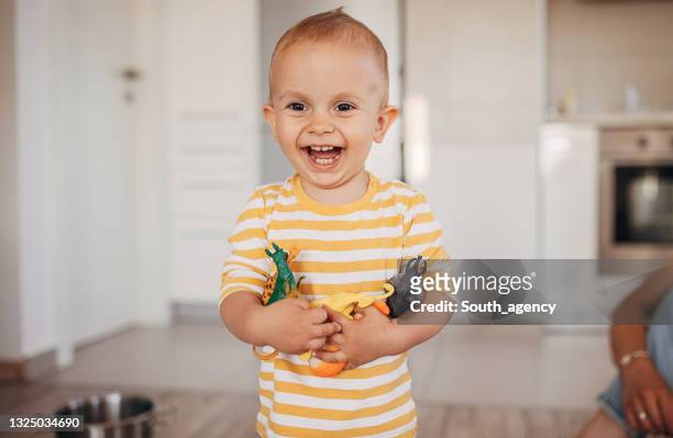 cute little boy holding toys - toy animal stockfoto's en -beelden