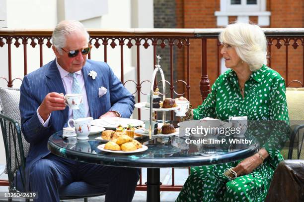 Prince Charles, Prince of Wales and Camilla, Duchess of Cornwall have tea on the terrace during a visit to Theatre Royal on June 23, 2021 in London,...