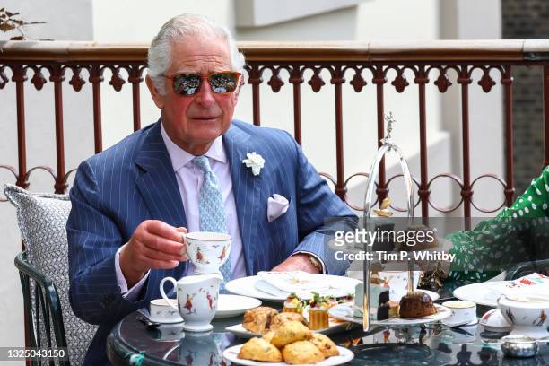 Prince Charles, Prince of Wales having tea on the terrace during a visit to Theatre Royal on June 23, 2021 in London, England. Theatre Royal Drury is...