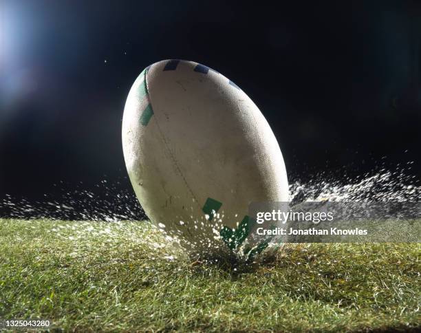 rugby ball in wet grass - rugbyball stock-fotos und bilder