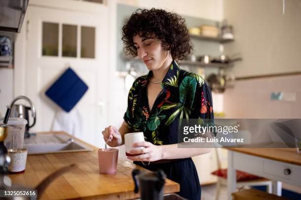 non-binary person making coffee at home - everyday life in berlin stock pictures, royalty-free photos & images