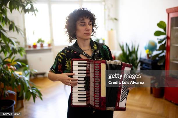 non-binary person playing vintage accordion at home - non musicians stock pictures, royalty-free photos & images