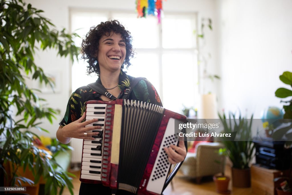 Non-binary person enjoying playing accordion