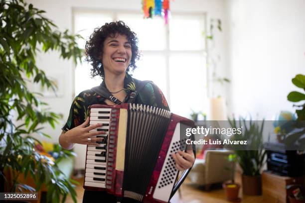 non-binary person enjoying playing accordion - accordion instrument stock pictures, royalty-free photos & images