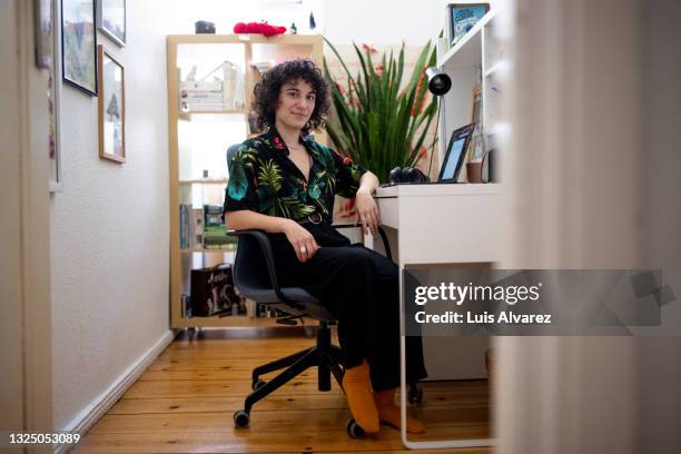 non-binary person sitting at home office desk - androgynous professional stock pictures, royalty-free photos & images