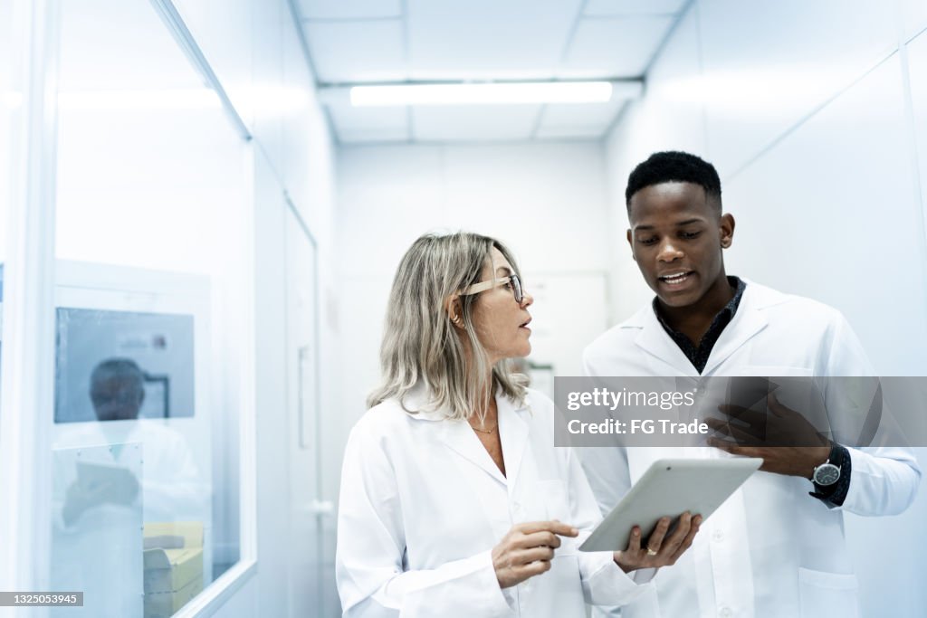 Colleagues using digital tablet in laboratory
