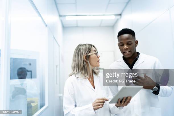 colleagues using digital tablet in laboratory - laboratory stock pictures, royalty-free photos & images
