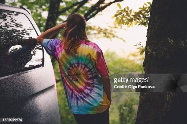 cropped photo of a man wearing a tie-dye t-shirt. - tie dye shirt stock pictures, royalty-free photos & images