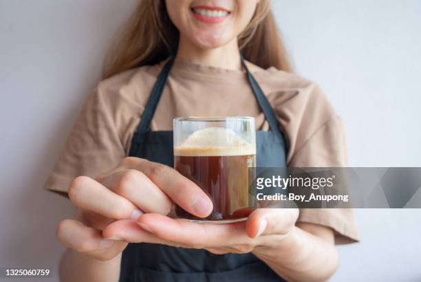 asian woman holding a cup of espresso coffee. - espressomaschine stock-fotos und bilder