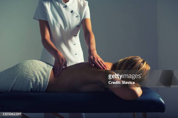 terapeuta de masaje femenino dando masajes a la mujer en el spa de salud - massage room fotografías e imágenes de stock