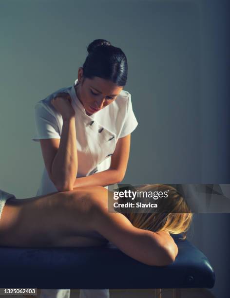 massaggiatore donna che regala massaggio alla donna in spa sanitaria - massage room foto e immagini stock