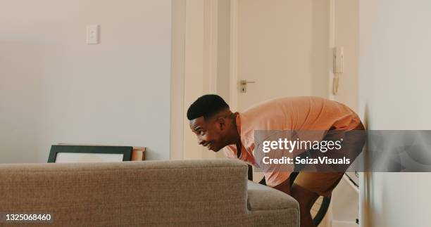 shot of a young man moving a couch at home - lift carry stock pictures, royalty-free photos & images
