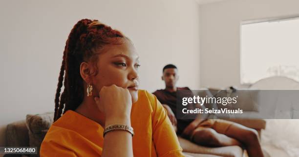 shot of a young woman ignoring her bf at home - couple unhappy stock pictures, royalty-free photos & images