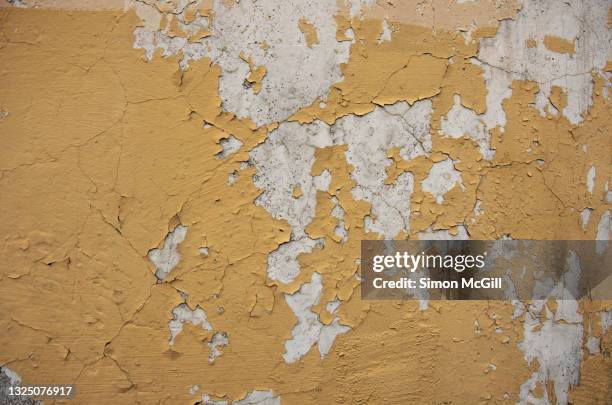 yellow paint peeling off a concrete stucco wall - peeled stock pictures, royalty-free photos & images