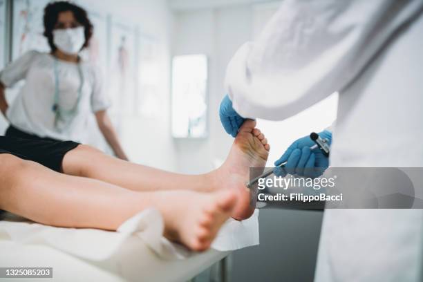 a doctor is examining a boy's legs and feet - tickling feet 個照片及圖片檔