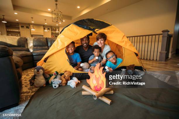 young family camping at home - camping indoors stock pictures, royalty-free photos & images