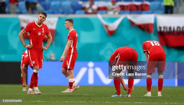 Jan Bednarek of Poland looks dejected with team mates following defeat in the UEFA Euro 2020 Championship Group E match between Sweden and Poland at...