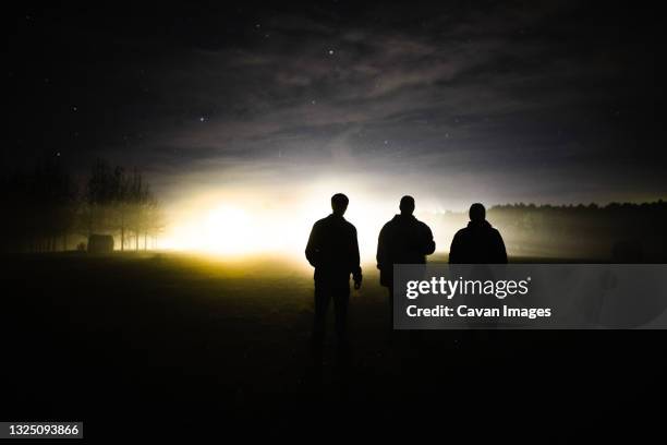 three men at dusk - three people silhouette stock pictures, royalty-free photos & images