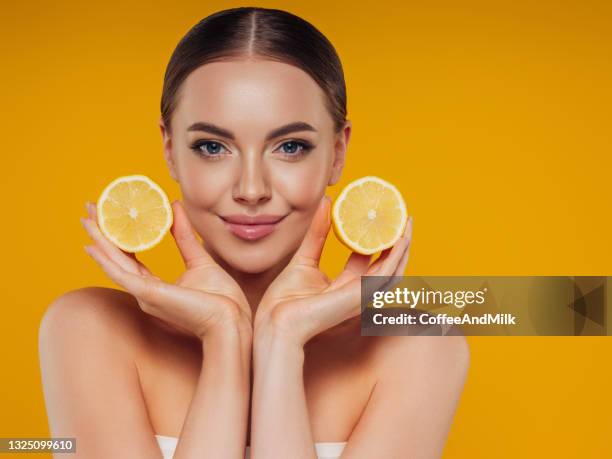 bella ragazza che mostra un limone - vitamina c foto e immagini stock