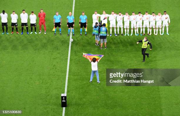 Pitch invader with a rainbow flag is seen on the pitch as the players line up prior to the UEFA Euro 2020 Championship Group F match between Germany...