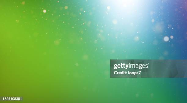 natürliche grün blau farbverlauf hintergrund mit defokussierten lichtern und partikeln - green background stock-grafiken, -clipart, -cartoons und -symbole