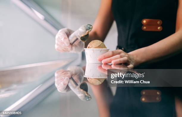 close up of scooping ice cream in gelato cafe - freezing hands stockfoto's en -beelden