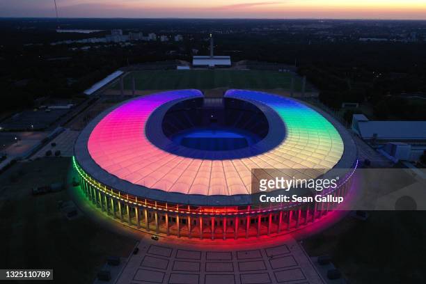 In this aerial view the Olympiastadion stadium stands illuminated in LGBT rainbow colors on June 23, 2021 in Berlin, Germany. Stadiums and landmarks...