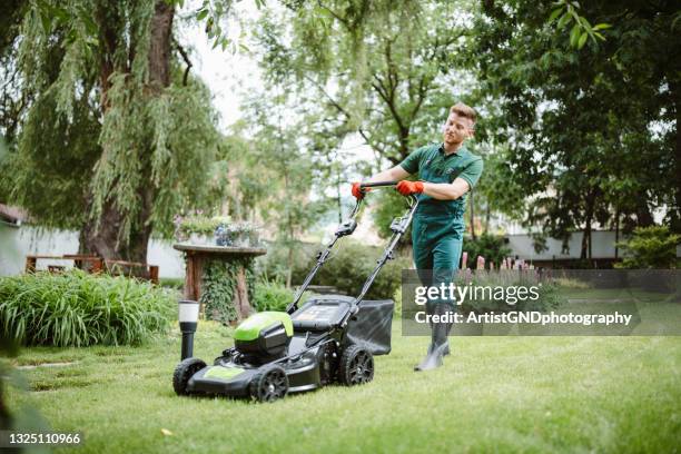 gardener mows the lawn with an mower. - gräsklippning bildbanksfoton och bilder