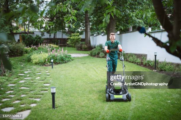 gärtner mäht den rasen mit einem mäher. - mowing lawn stock-fotos und bilder