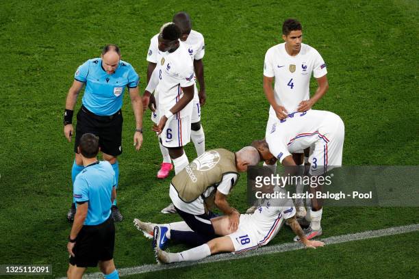 Lucas Digne of France receives medical treatment during the UEFA Euro 2020 Championship Group F match between Portugal and France at Puskas Arena on...