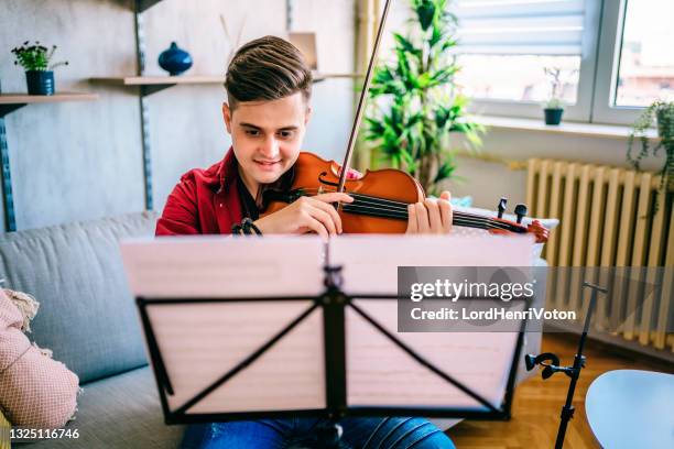 man violinist practicing violin at home - muziekstandaard stockfoto's en -beelden